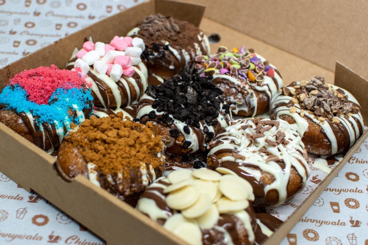 Box of donuts loaded with a variety of toppings