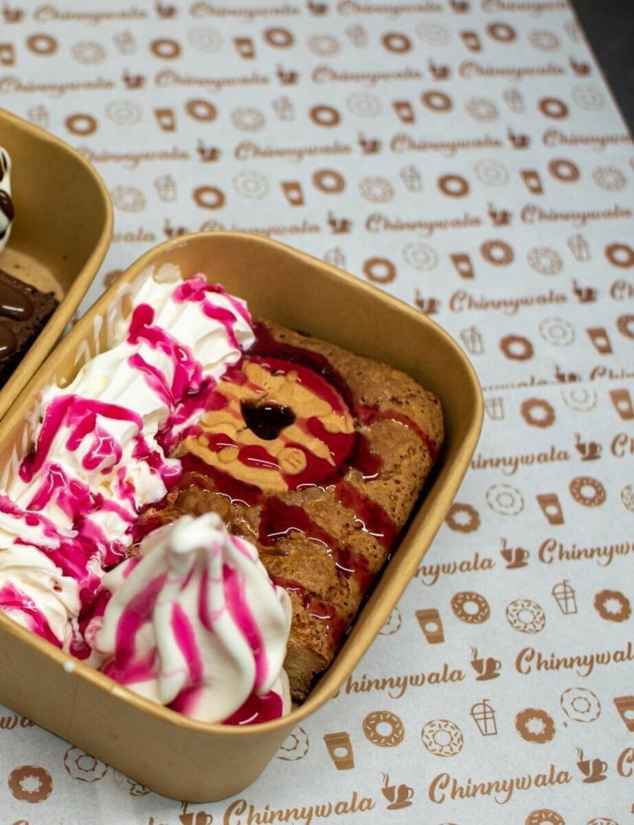 Jammy Dodger Brownie with cream and berry drizzle