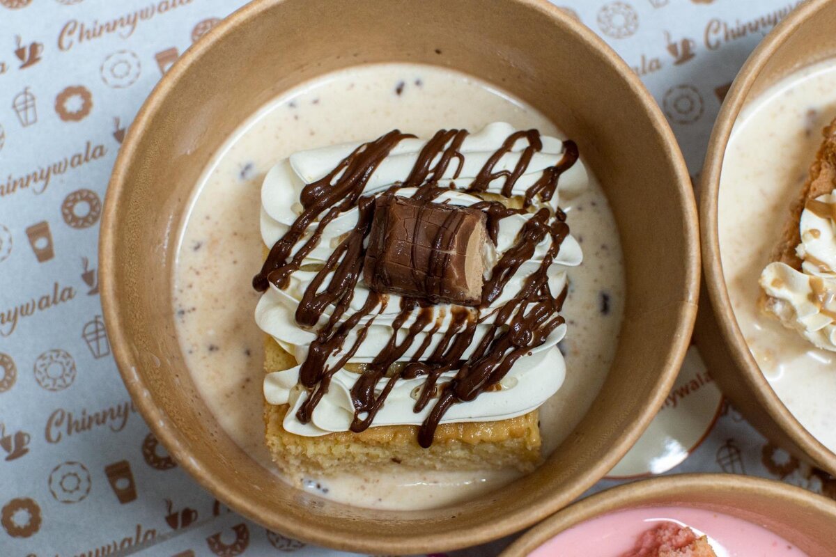 Kinder Bueno Milk Cake with cream and chocolate drizzle